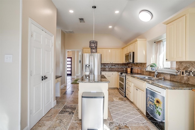 kitchen featuring a center island, sink, stainless steel appliances, pendant lighting, and lofted ceiling