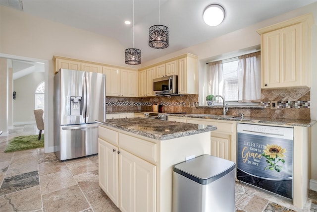 kitchen with stainless steel appliances, sink, pendant lighting, dark stone countertops, and a kitchen island