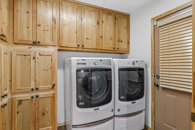 clothes washing area featuring cabinet space and separate washer and dryer