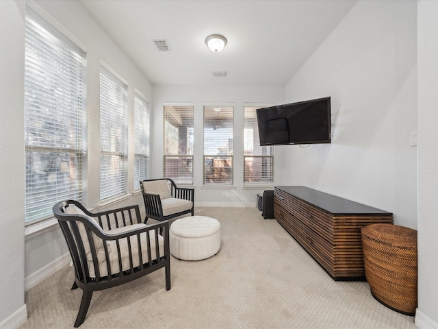 living area featuring light carpet