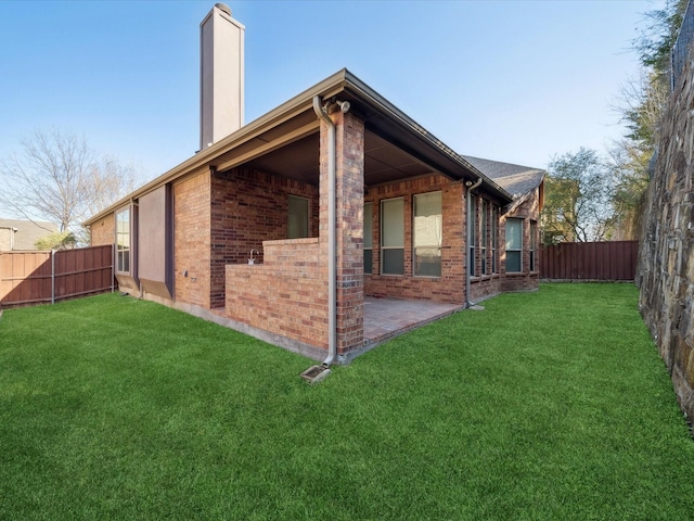 back of house with a patio area and a lawn