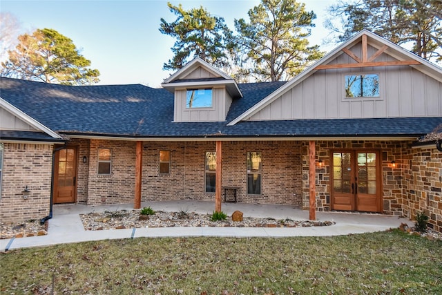 back of property with a lawn, a patio, and french doors