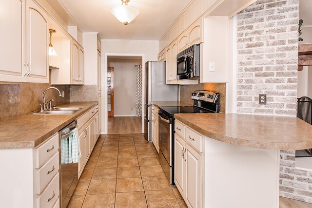 kitchen with kitchen peninsula, tasteful backsplash, stainless steel appliances, sink, and decorative light fixtures