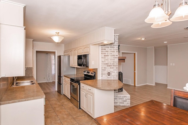 kitchen with decorative light fixtures, crown molding, sink, and appliances with stainless steel finishes