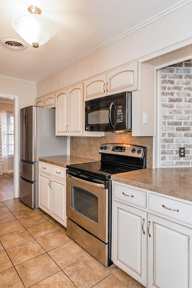 kitchen with decorative backsplash, light tile patterned floors, stainless steel appliances, and crown molding