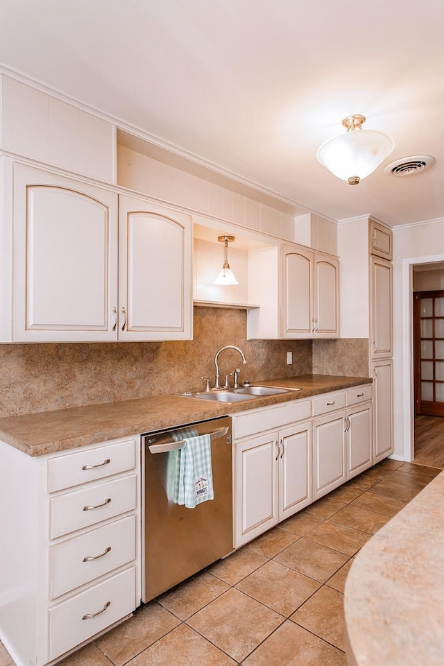 kitchen with sink, tasteful backsplash, stainless steel dishwasher, pendant lighting, and light tile patterned floors