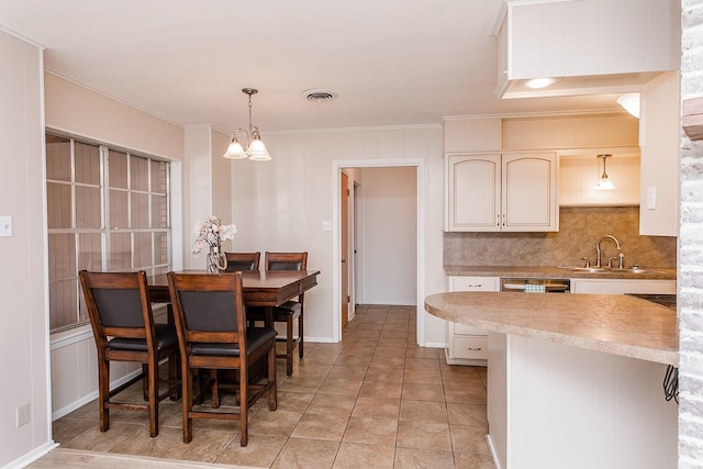 kitchen featuring sink, hanging light fixtures, an inviting chandelier, a kitchen breakfast bar, and light tile patterned floors