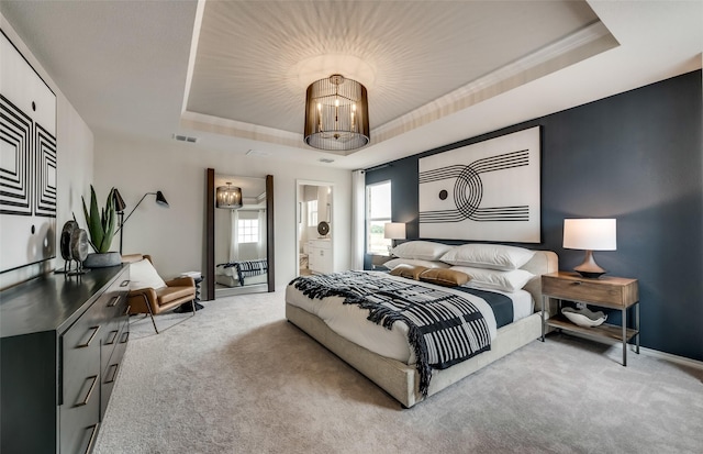 bedroom with crown molding, light colored carpet, and a raised ceiling