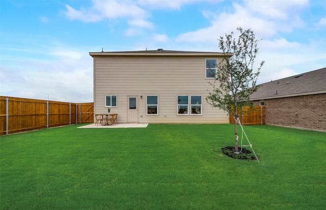 rear view of house with a yard and a patio area