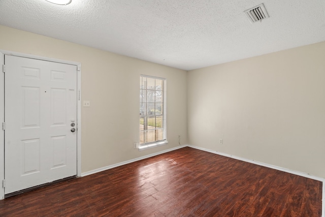 entrance foyer featuring a textured ceiling and dark wood-type flooring