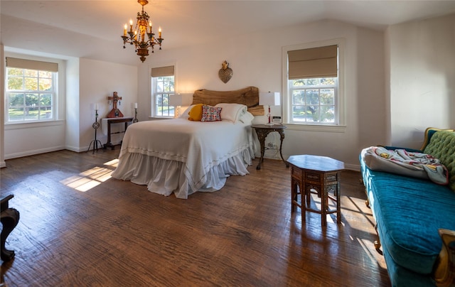 bedroom featuring vaulted ceiling, dark hardwood / wood-style floors, and a chandelier