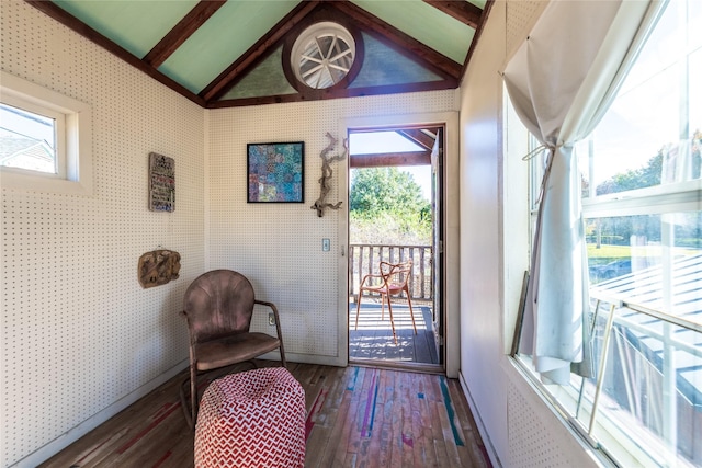 doorway with a wealth of natural light, dark hardwood / wood-style flooring, and lofted ceiling with beams