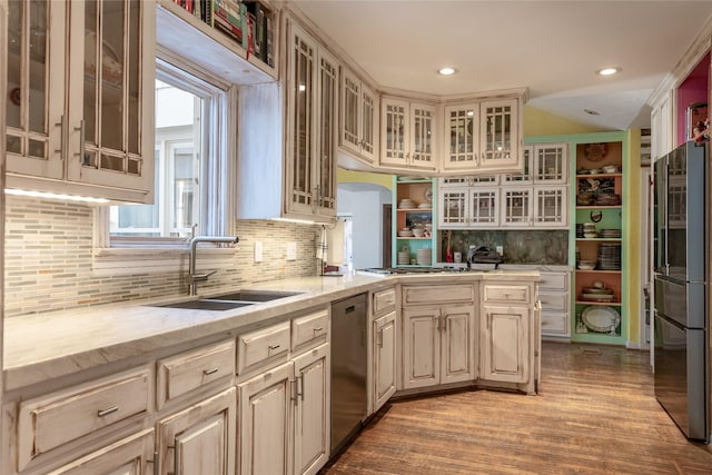 kitchen featuring sink, light hardwood / wood-style flooring, cream cabinetry, and appliances with stainless steel finishes