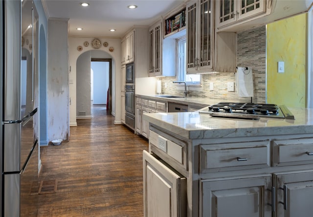 kitchen with kitchen peninsula, stainless steel appliances, tasteful backsplash, and sink