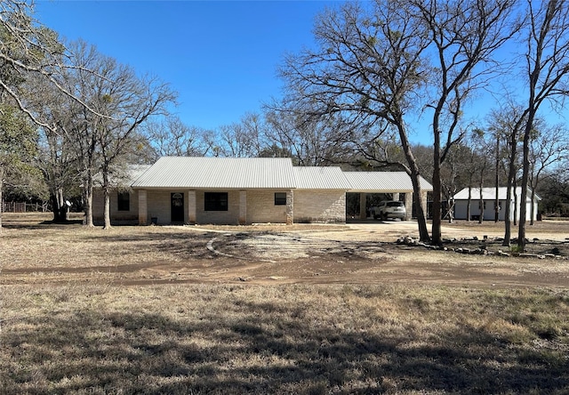 view of front of house featuring dirt driveway, metal roof, and an attached carport