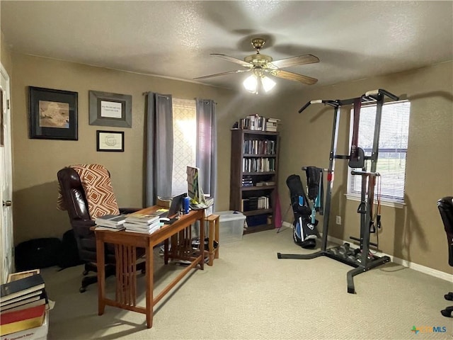 office area featuring baseboards, carpet, a ceiling fan, and a healthy amount of sunlight