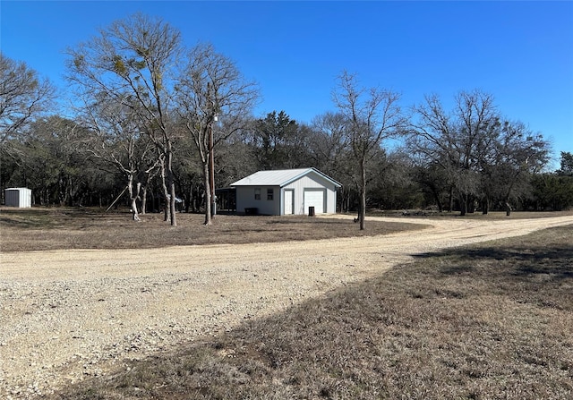 view of yard with driveway and an outdoor structure