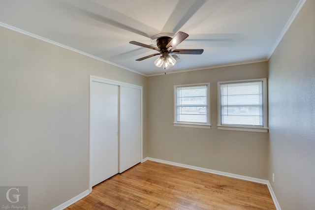 unfurnished bedroom with ceiling fan, ornamental molding, a closet, and light wood-type flooring