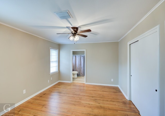 unfurnished bedroom with crown molding, light wood-type flooring, baseboards, ensuite bath, and ceiling fan
