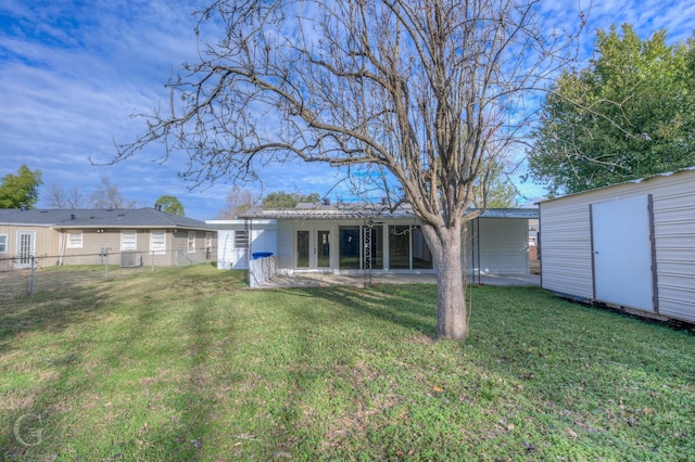 back of house featuring a storage shed and a lawn