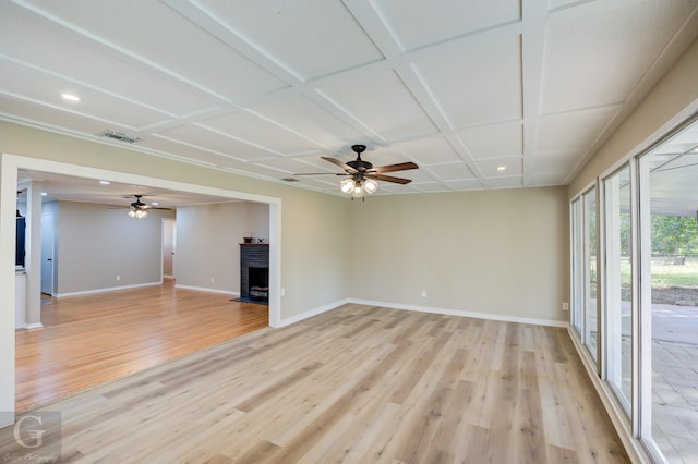 unfurnished living room featuring coffered ceiling, a fireplace, ceiling fan, and light hardwood / wood-style flooring