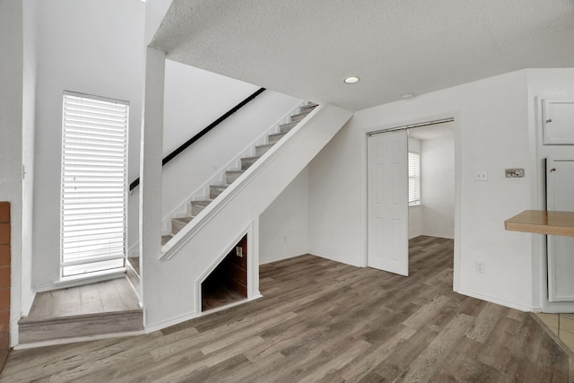 unfurnished living room with a textured ceiling and hardwood / wood-style flooring