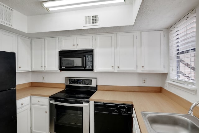 kitchen with black appliances, white cabinetry, sink, and a textured ceiling