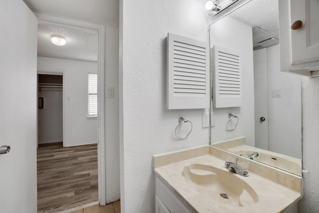 bathroom featuring vanity, hardwood / wood-style floors, and a textured ceiling