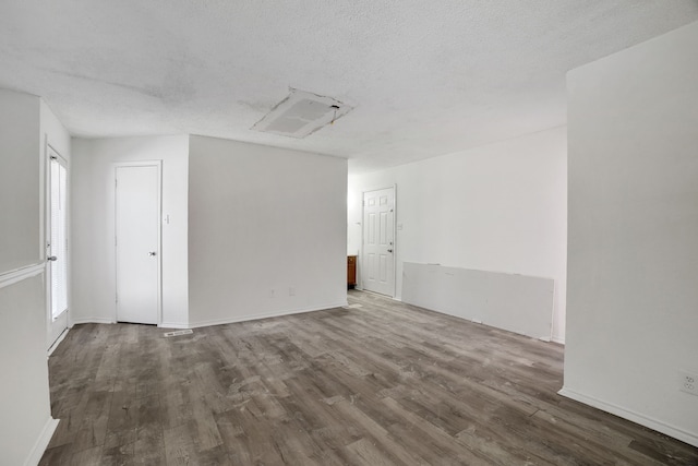 unfurnished room with dark wood-type flooring and a textured ceiling