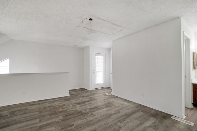 empty room featuring dark wood-type flooring and a textured ceiling