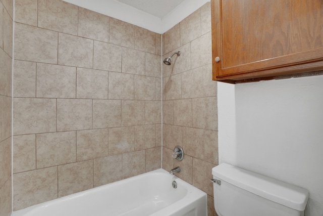 bathroom with tiled shower / bath combo and toilet