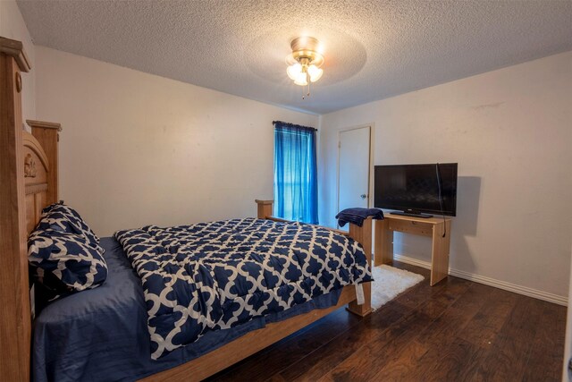 bedroom featuring ceiling fan, dark wood-type flooring, and a textured ceiling