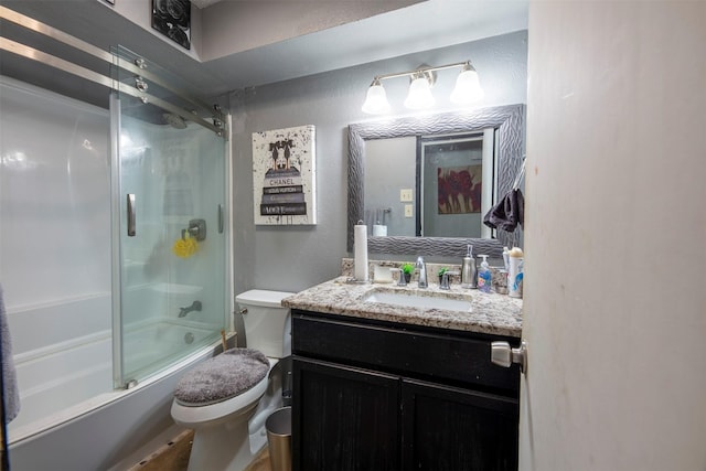 full bathroom featuring vanity, toilet, and shower / bath combination with glass door