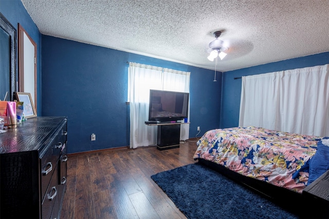 bedroom featuring ceiling fan, dark hardwood / wood-style flooring, and a textured ceiling