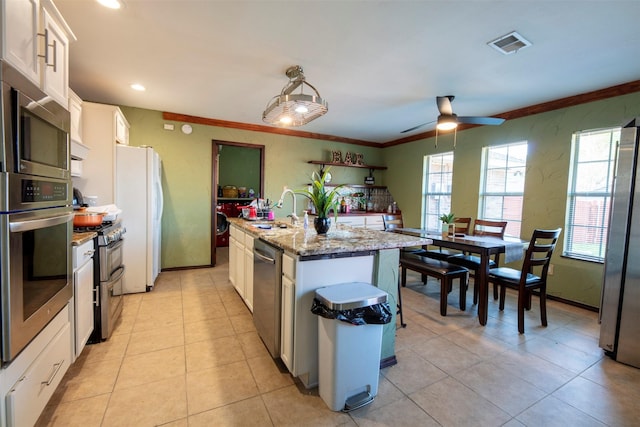 kitchen with ceiling fan, white cabinetry, sink, an island with sink, and appliances with stainless steel finishes