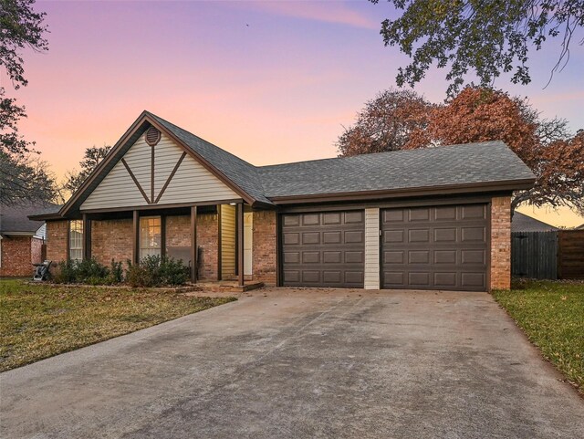 ranch-style house featuring a garage and a lawn