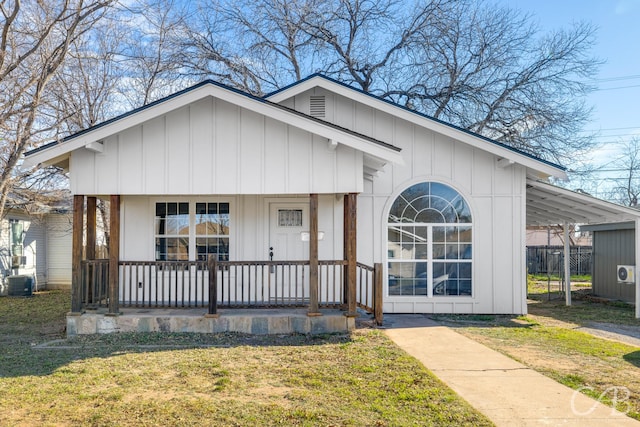 view of front facade featuring central AC, a front lawn, a carport, and covered porch