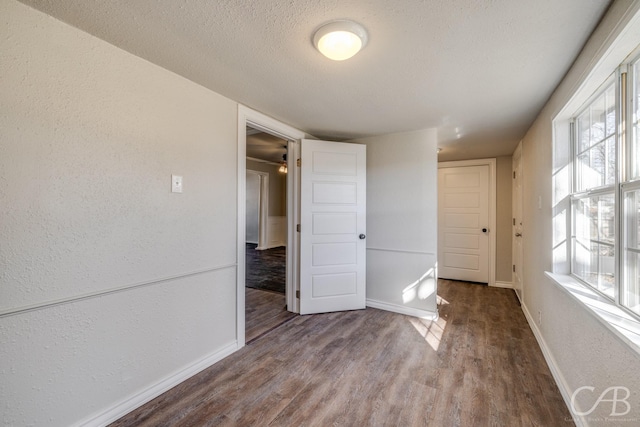 spare room featuring hardwood / wood-style floors and a textured ceiling