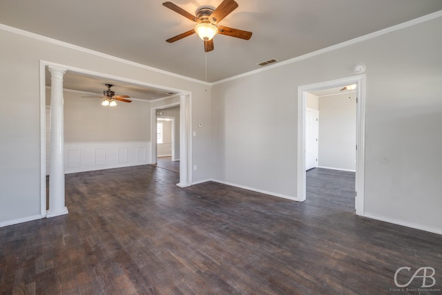 spare room with dark hardwood / wood-style floors, decorative columns, ornamental molding, and ceiling fan