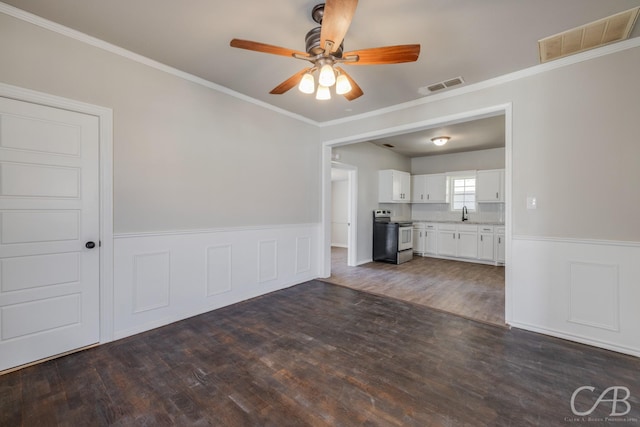 unfurnished living room with ceiling fan, sink, dark hardwood / wood-style floors, and ornamental molding