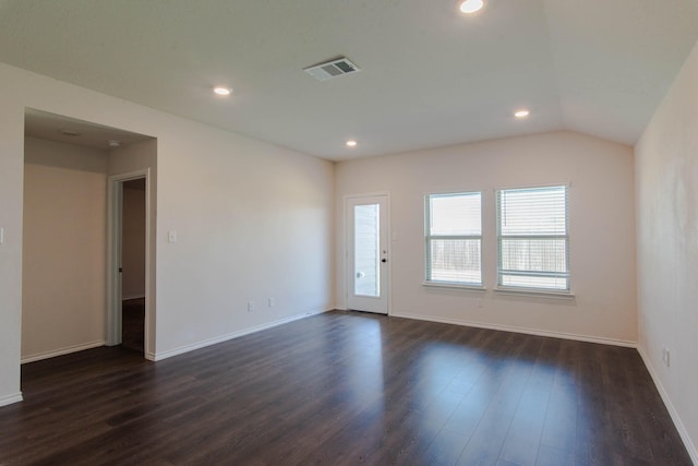 spare room featuring dark hardwood / wood-style flooring and vaulted ceiling