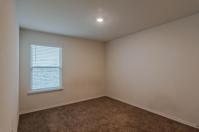 empty room with dark colored carpet