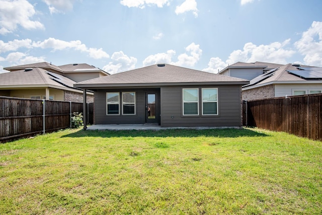 back of property with a yard and a patio