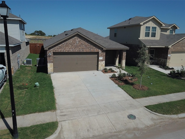 view of front of house featuring a front lawn, a garage, and cooling unit