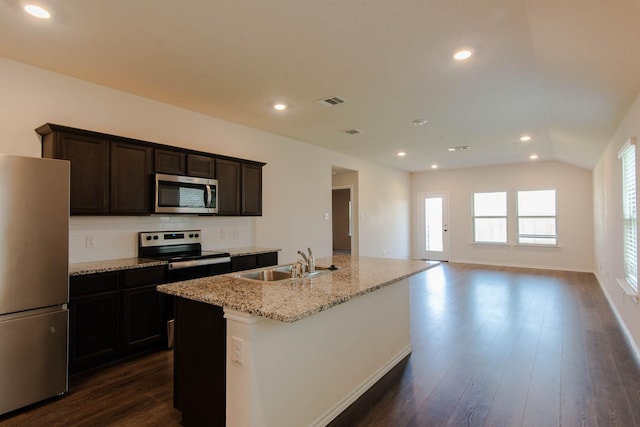 kitchen featuring appliances with stainless steel finishes, backsplash, sink, dark hardwood / wood-style floors, and an island with sink