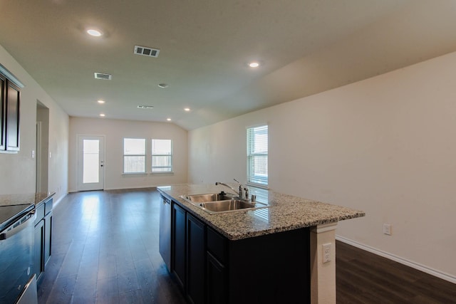 kitchen featuring stainless steel range, sink, a healthy amount of sunlight, and a center island with sink