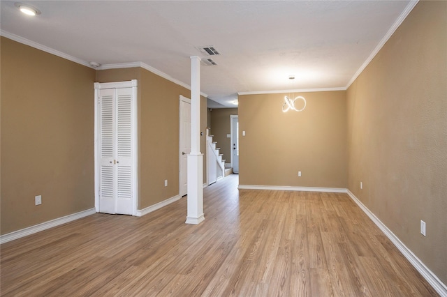 spare room with hardwood / wood-style flooring, ornamental molding, and a chandelier