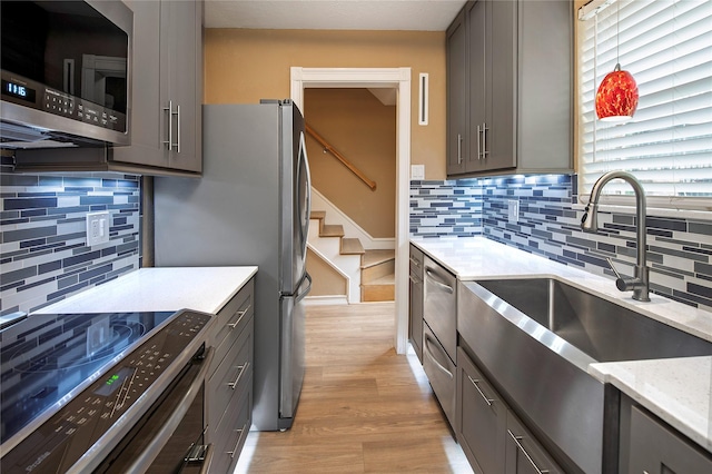 kitchen featuring dark hardwood / wood-style flooring, stainless steel appliances, gray cabinetry, and sink