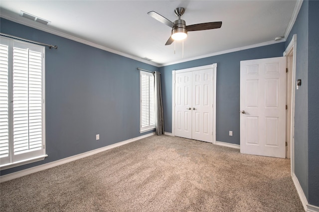 unfurnished bedroom with ceiling fan, carpet, and ornamental molding