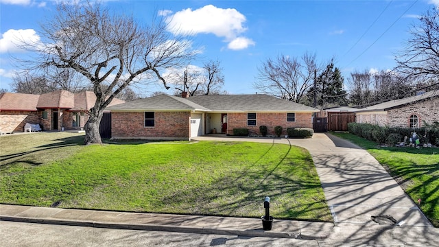 view of front facade featuring concrete driveway, an attached garage, fence, a front lawn, and brick siding